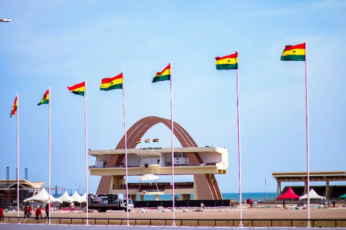 Ghana's independence square with flags and a clear sky.