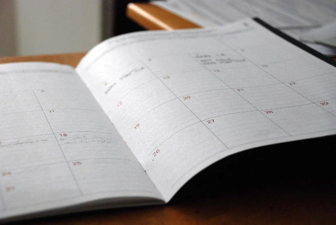 open monthly planner on wooden desk