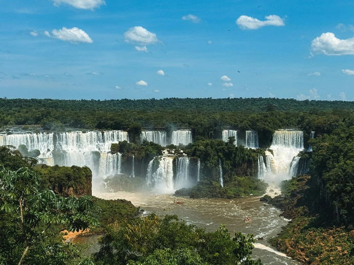 A view of a large waterfall in the middle of a forest