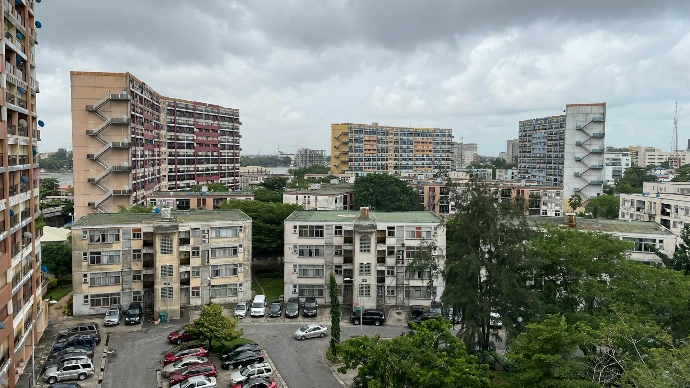 cars parked on parking lot near high rise buildings during daytime