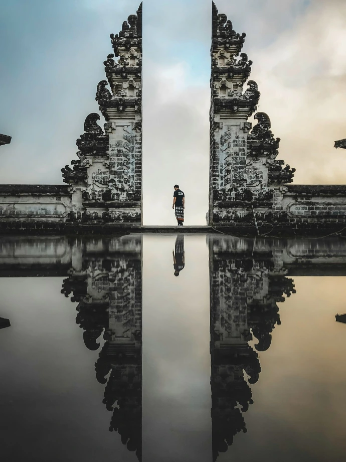 man standing between ruins in reflective photography
