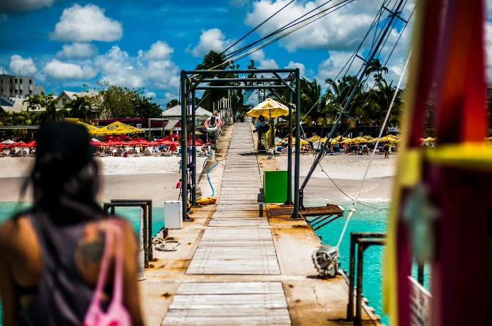 a woman standing on a pier next to a body of water
