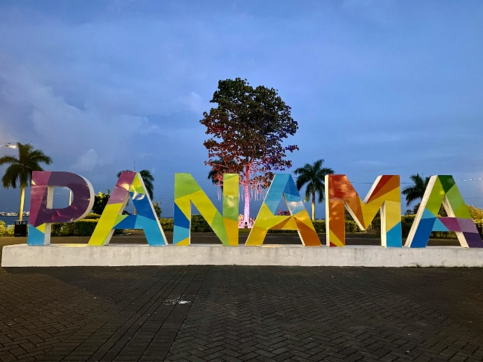 a large sign that says panama with a tree in the background